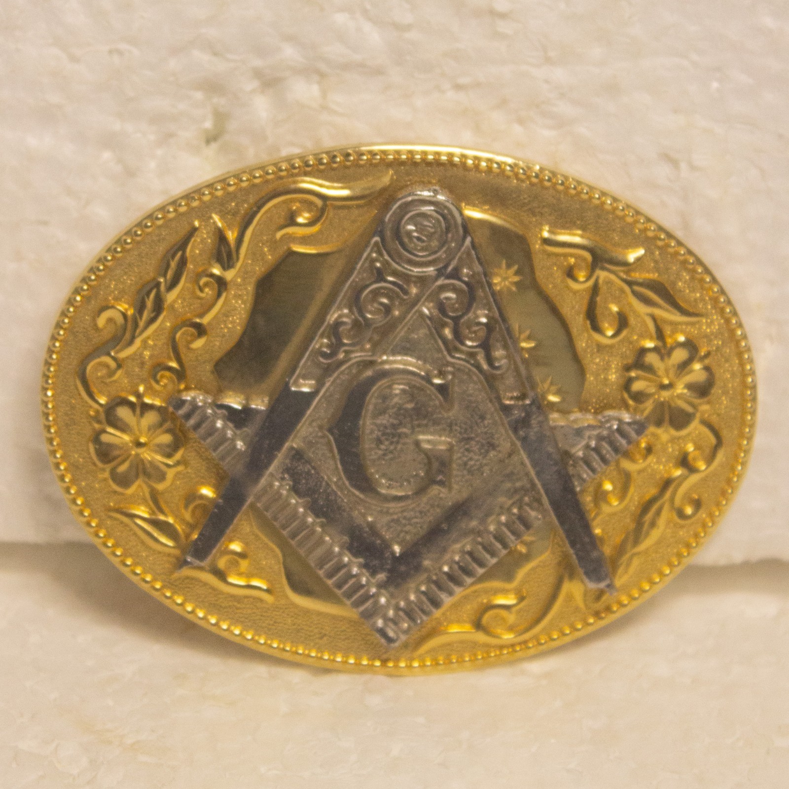 Vintage Masonic belt buckle featuring a gold‑tone oval base with a raised silver